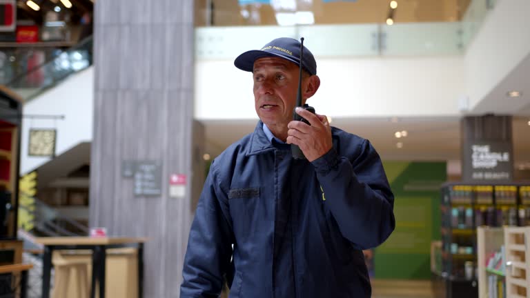 Security guard at the mall talking with colleagues using a walkie talkie