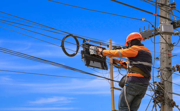 istock technician on wooden ladder is installing fiber optic system in internet splitter box on electric pole against blue sky 1328252972