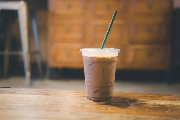 Photo of Iced coffee Mocha on wooden working space background and blur background