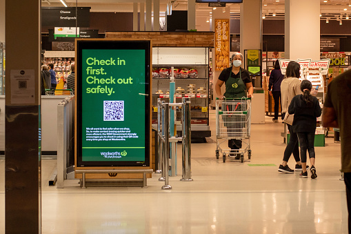 Sydney, Australia 2021-01-07: Exterior view of Woolworths Miranda supermarket during the COVID-19 pandemic lockdown. QR-code. Check in advertisement