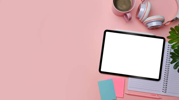 istock Top view mock up digital tablet, notebook, sticky note and coffee cup on pink background. 1328260221