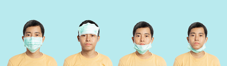 Young man showing right and wrong way to wearing mask protection. How to properly use a face mask.