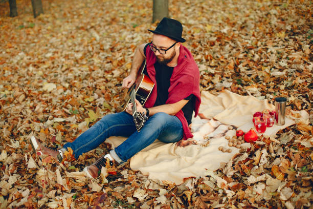 istock Handsome man sitting in a autumn park 1328263912