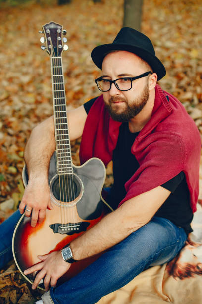 istock Handsome man sitting in a autumn park 1328263913