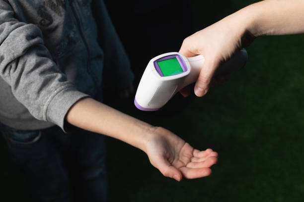 istock Measuring temperature on child's hand using non contact device infrared thermometer gun 1328266436