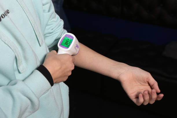 istock Self-measurement temperature using an infrared electronic digital thermometer on your hand. body temperature of 36.5 1328266538