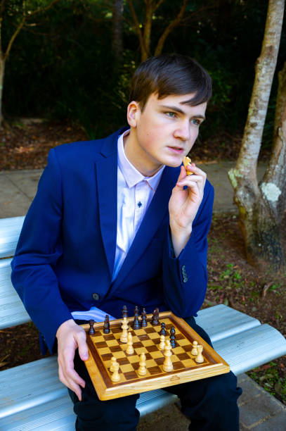 istock Teenage boy with his chess board considers his next move. 1328267465