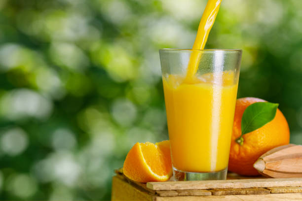 istock cold freshly squeezed orange juice pouring into glass 1328267668