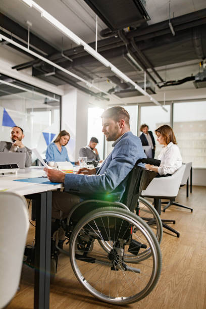 istock Disabled businessman working on paperwork during a meeting in the office. 1328271954