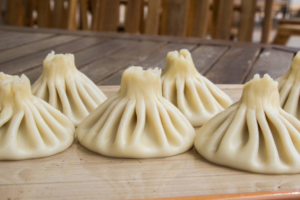 Georgian traditional food khinkali on the plate in restaurant, ready to eat, hot dish on the wooden table.
