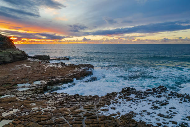 istock Aerial sunrise seascape with clouds and rock platform 1328274636