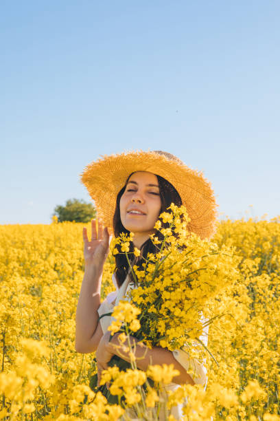 istock woman standing in rapeseed field 1328276524