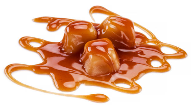 istock Caramel candies covered with melted sugar caramel isolated on white background. 1328277957