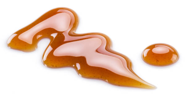 istock Sugar caramel sauce curls isolated on white background. Top view. 1328277959