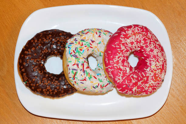 istock multicolored donuts with glaze on a white plate 1328279417