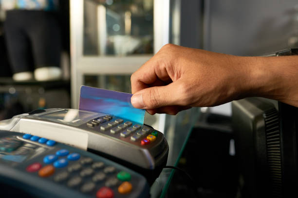 cajero deslizando la tarjeta de crédito - credit card reader fotografías e imágenes de stock