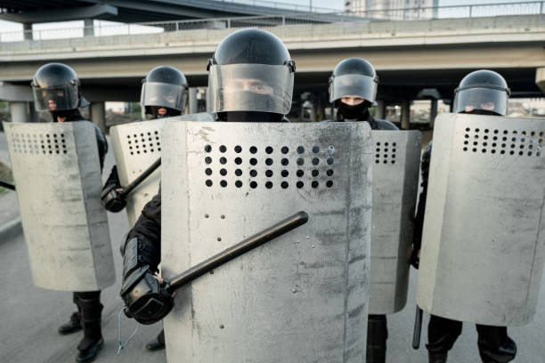 istock Riot police pushing back protestors 1328280888