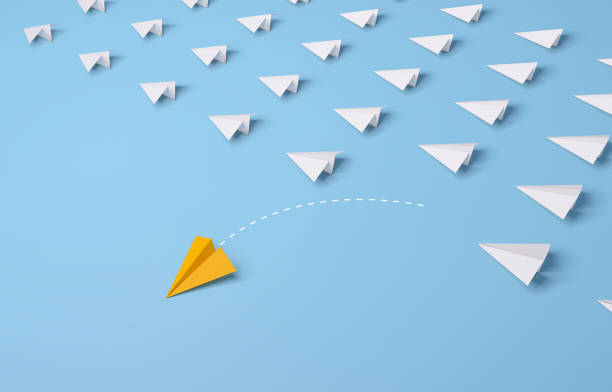 istock Individual and unique leader yellow paper airplane changing direction on blue background. 1328280930