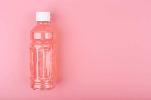 istock Flat lay with pink drink in transparent plastic bottle against bright pink background with copy space 1328281939