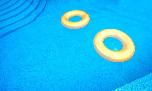 gold colored pvc inflatable swimming tubes (inflatable rings) in the pool. - swimming tube inflatable circle imagens e fotografias de stock