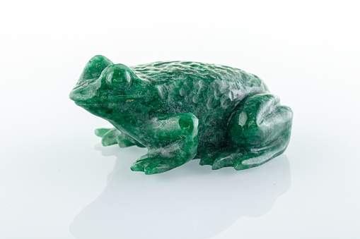 beautiful figurine of a toad made of malachite on a white background close-up