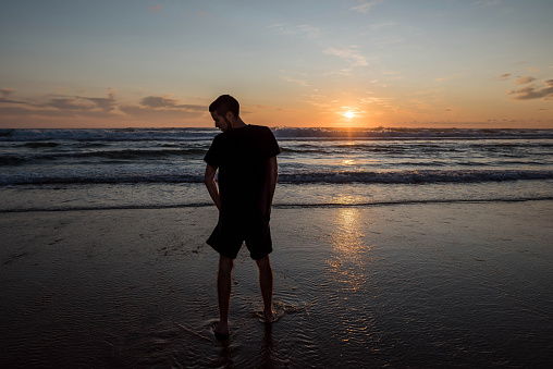 young man enjoying a beautiful sunset on the beach