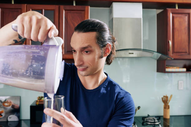 istock Fot Man Pouring Protein Drink 1328289816