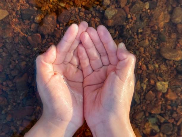 istock Handful of pure freshwater against river pebbles bottom 1328291506