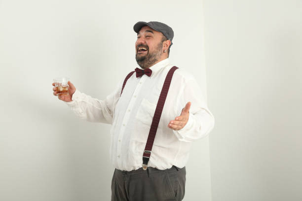 istock young man making gestures with his hands and face and drinking whiskey, telling something with a cheerful smile 1328291520