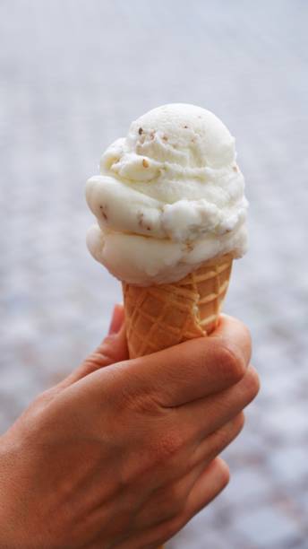 istock Refreshing ice cream in a waffle in hand on a street 1328292494