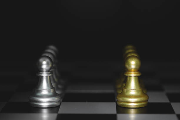 istock pawn chess pieces battle, golden and silver chess on a chessboard. concept for strategy, business victory. 1328294080