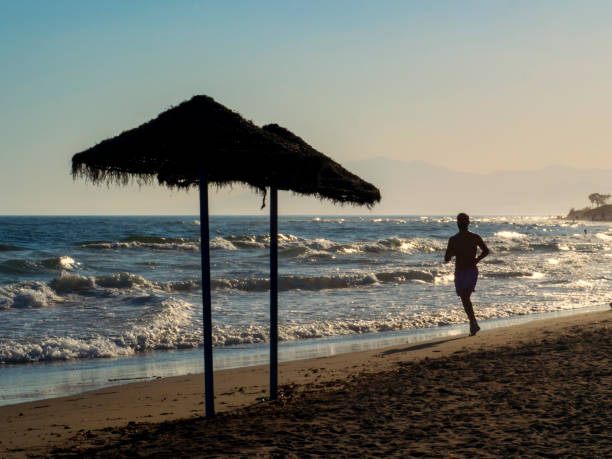 Silhouette of man running on the beach stock photo