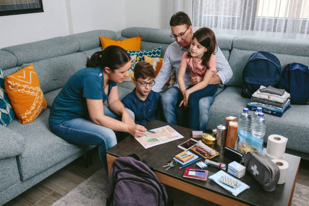 Mother explaining to her family the emergency assembly point Mother explaining to her family the assembly point map while preparing emergency backpacks first aid kit stock pictures, royalty-free photos & images