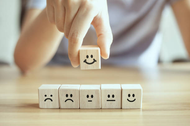 istock hand business man chooses a smiley face on woo block cube, service rating, satisfaction concept. 1328295733