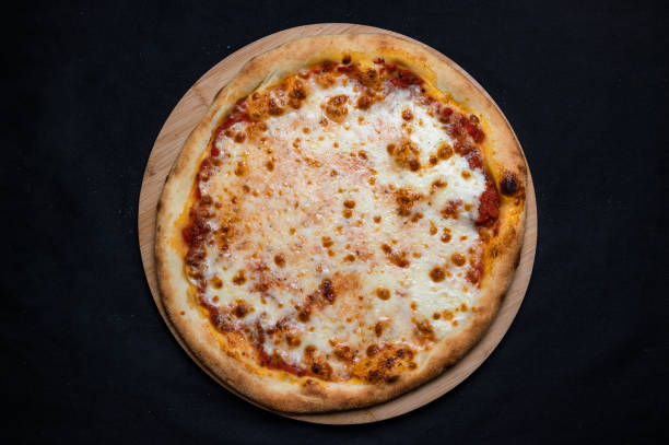 istock Pizza with tomato sauce and mozzarella cheese on a black background. 1328296500