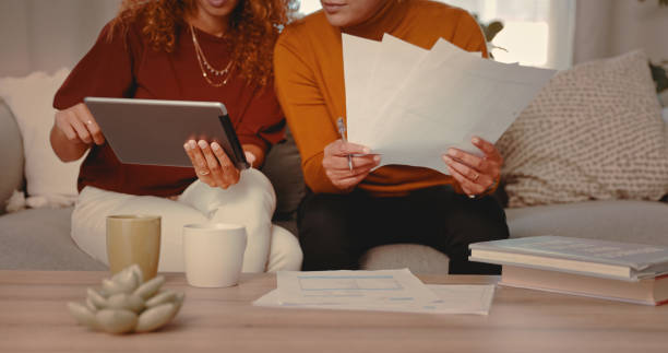 istock Shot of an unreognizable couple doing paperwork while using a digital tablet at home 1328296599