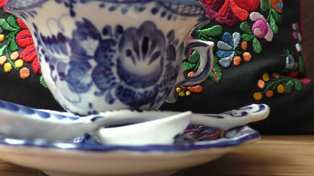 Teacup with saucer and teaspoon in Russian traditional Gzhel style. Gzhel-Russian folk craft of ceramics and production porcelain and a kind of Russian folk painting. Background blur