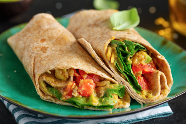 istock Tasty fresh vegan vegetarian wrap with spinach, tomato, avocado 1328302832
