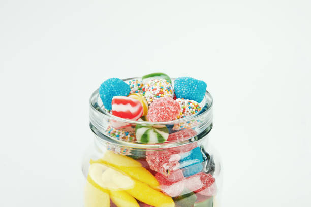 istock Assorted candies in a glass jar on a white background. 1328304372