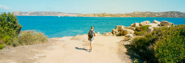 istock man walks next to the sea in Sardinia, web banner 1328305005