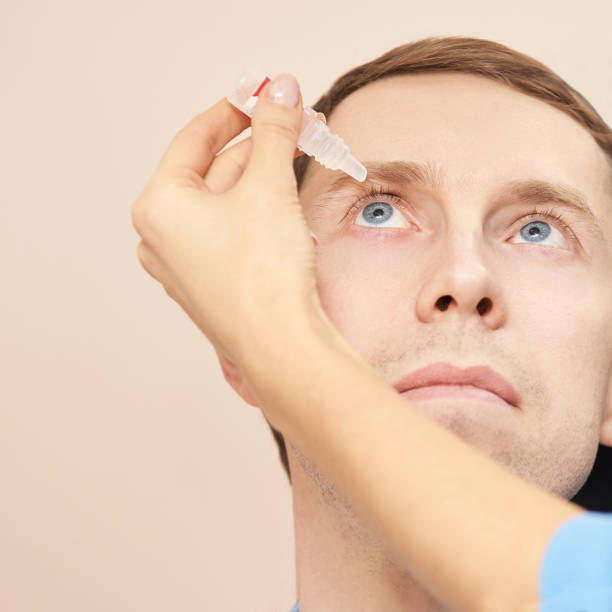 istock Doctor hold eye drops near patient face 1328305245