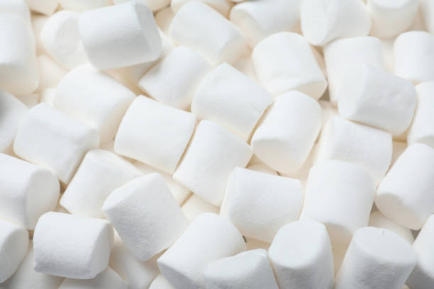 istock Delicious white puffy marshmallows as background, top view 1328305872