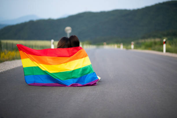 istock Lesbian couple wrapped in rainbow flag 1328306029