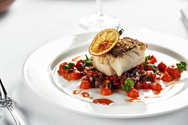 istock Black cod fillet on a vegetable stew, festive serving on a white grater on a table with white tablecloths 1328306476