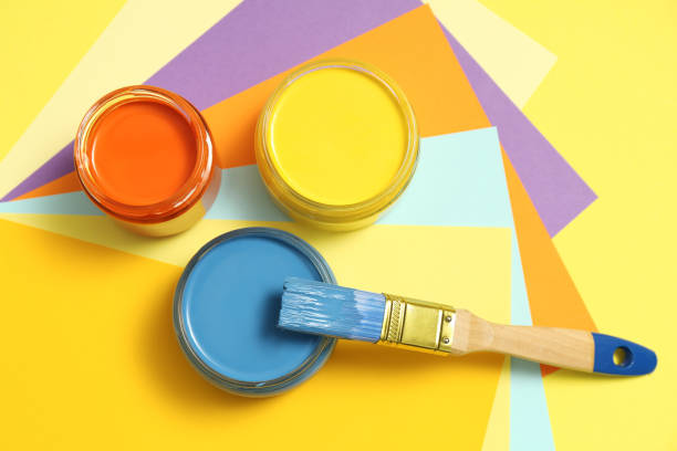 istock Jars of different paints and brush on color background, flat lay 1328306709