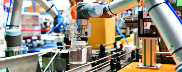 bouteille d’eau en verre disposée par bras robot sur l’équipement de machines industrielles automatiques dans l’usine de la ligne de production - robot robot arm plastic production line photos et images de collection