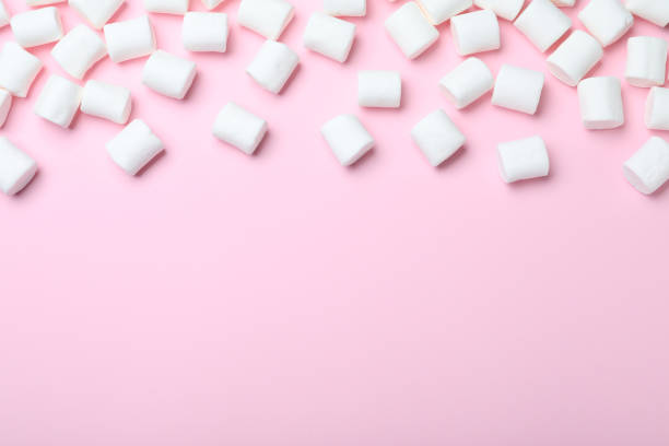 istock Delicious puffy marshmallows on pink background, flat lay. Space for text 1328307661
