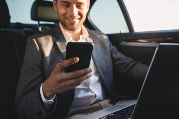 istock Smiling businessman holding mobile phone 1328307943