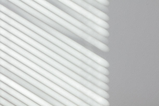 istock Shadow of window blinds on wall 1328308354