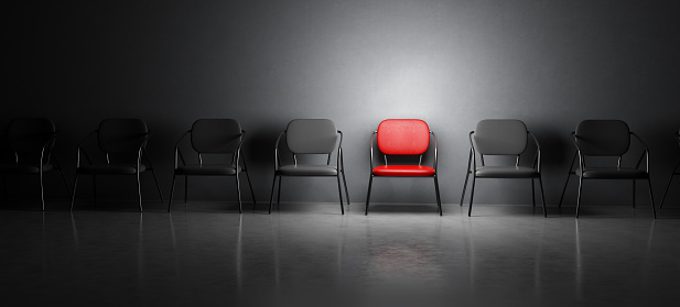 Red chair in spotlight in a row of black chairs. 3D illustration